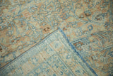 Detail of the vintage Khoy carpet's hand-knotted back, secured side cord, and pale blue fringe.