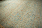 Angled view of the time-softened, low pile of a distressed Khoy carpet in apricot and pale sky blue tones.