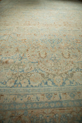 Evenly worn pile and hand-knotted texture of a distressed Persian rug in dusty apricot and sky blue.