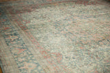 Angled view showing the worn texture and faded floral design of a distressed Mahal carpet.