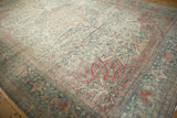 Corner detail of a distressed Mahal carpet with scrolled vines in faded teal and dusty red.