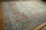 Angled view across a distressed vintage Mahal carpet highlighting its time-softened colors and texture.