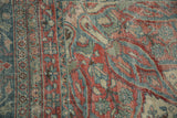 Low-pile texture of a distressed Mahal carpet with dusty red, blue, and jade green motifs.
