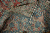 The secured side cord selvage and distressed, low-pile texture of a vintage Persian Mahal carpet.