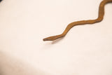 Close-up of the vintage Lobi iron snake head, showing its rustic brown, handmade texture.