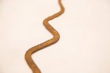 Hand-forged texture and deep rust patina on the vintage iron snake.