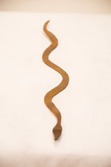 Hand-forged iron snake, showcasing its unique wavy form and rich rust patina.
