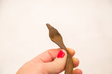 Hand holding the vintage iron snake, highlighting its unique handcrafted form.