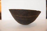 Side view of vintage African wooden bowl, highlighting primitive carved lines and dark wood.