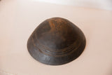 Vintage African wooden bowl showing hand-carved lines and dark, aged wood texture.