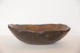 Vintage African wooden bowl, displaying primitive hand-carved wood texture and aged surface.