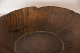 Hand-carved dark brown vintage African wooden bowl with textured interior and surface imperfection.