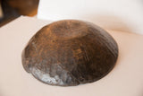 Primitive hand-carved African wooden bowl exterior with deep crack and visible markings.