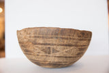 Primitive carved lines and deep crack on vintage African wooden bowl.