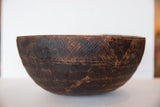 Hand-carved geometric patterns and rich patina on the side of the vintage wooden bowl.