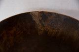 Prominent crack and textured, aged wood surface on the vintage African bowl's rim.