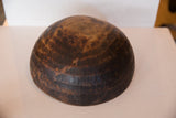 Dark wood of vintage African bowl, with primitive etched patterns and a visible crack.
