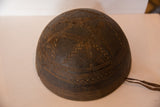 Dark wood detail of vintage African bowl, primitive carved geometric patterns and visible crack.
