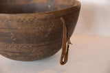 Primitive carved zigzag patterns and aged leather handle on the vintage wooden bowl.