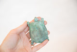 Handheld vintage African copper turtle, featuring its textured shell and beautiful green patina.