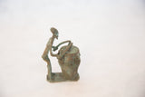 The stylized profile and textured patina of the handmade African copper drummer.