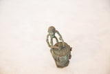 High-angle view of the vintage copper drummer showing its aged patina.