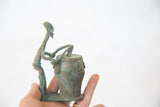 Vintage African drummer sculpture in profile showing its slender form and oxidized patina.