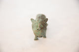 The carved face of a vintage copper wild animal with a time-worn green patina.