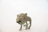 Snarling face of a vintage African copper wild thing with oxidized green patina.