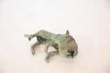 Low angle view showing the face and front paws of the oxidized copper animal.