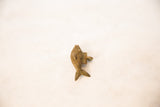 The handmade form and aged bronze texture of an African fish pendant.
