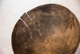 Primitive African wooden bowl, highlighting age cracks and natural wood grain.