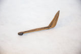 Curved vintage African wooden spoon, showing hand-carved primitive details on its brown handle.
