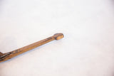 Primitive hand-carved details and aged texture on the wooden spoon handle end.