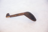 Aged, hand-carved vintage African wooden spoon, showcasing its dark primitive texture.