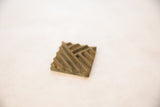 Rich patina and carved geometric texture on a square African bronze coin.