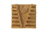 Vintage African square bronze coin stamp with central V-motif, spiral, and earthy patina.