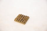 Vintage African square bronze coin featuring a raised geometric pattern and aged patina.