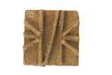 Vintage African square bronze coin showing its rough, handmade texture and raised geometric pattern.