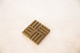 Vintage African square bronze coin with intricate, textured interwoven pattern.
