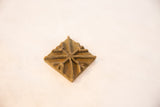 Raised geometric star pattern and aged texture on a square bronze coin.