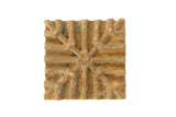 Vintage African square bronze coin with a raised geometric starburst pattern and aged patina.