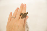 Vintage cast bronze lizard ring worn on a hand, showing its textured profile.