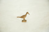 Vintage bronze bird with a rustic patina and incised circular wing patterns.