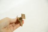 Rear view of a vintage bronze bird showing its squared tail and textured body.