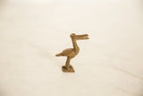 Side profile of a vintage African bronze bird with a long neck and textured, handmade details.