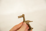 Side profile of a vintage African bronze bird with a stylized, long-legged form and textured surface.