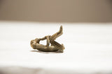 Vintage African bronze monkey sculpture, highlighting its aged, textured surface from a low angle.