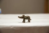 Profile view of a vintage African bronze boar showing its textured spine and aged patina.