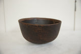 Natural aged dark brown wood texture and rounded base of the vintage African bowl.